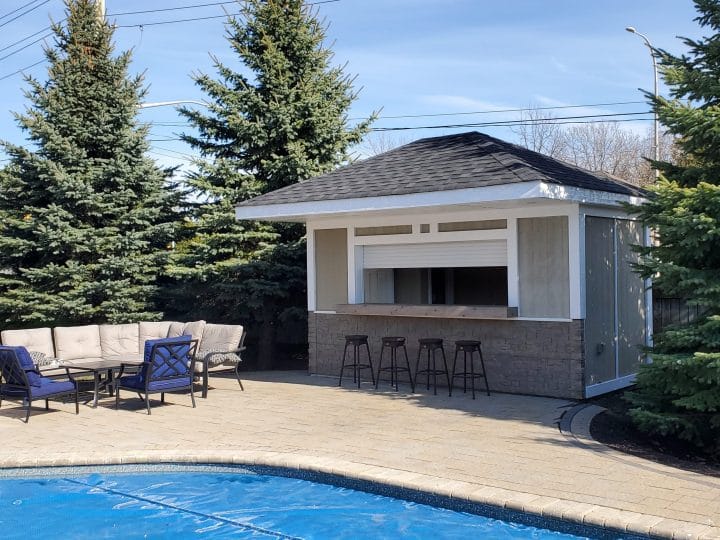 Pool house with roll-up shutters and pool in the foreground