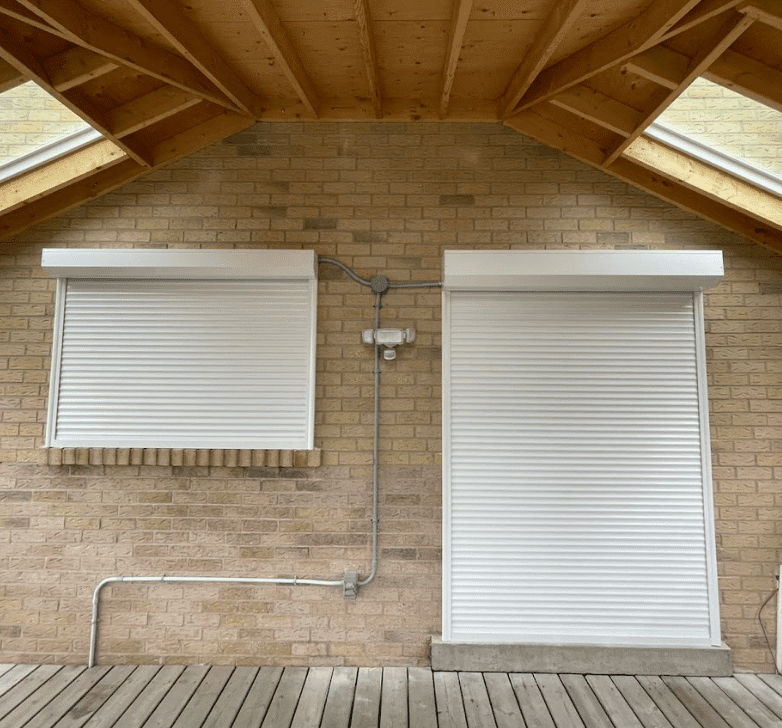 Roll-up shutters installed over patio doors on a residential home