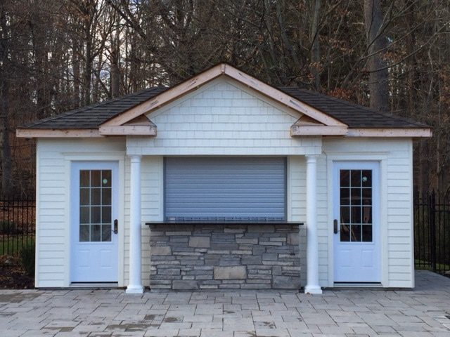 White roll-up shutter installed on a residential outbuilding