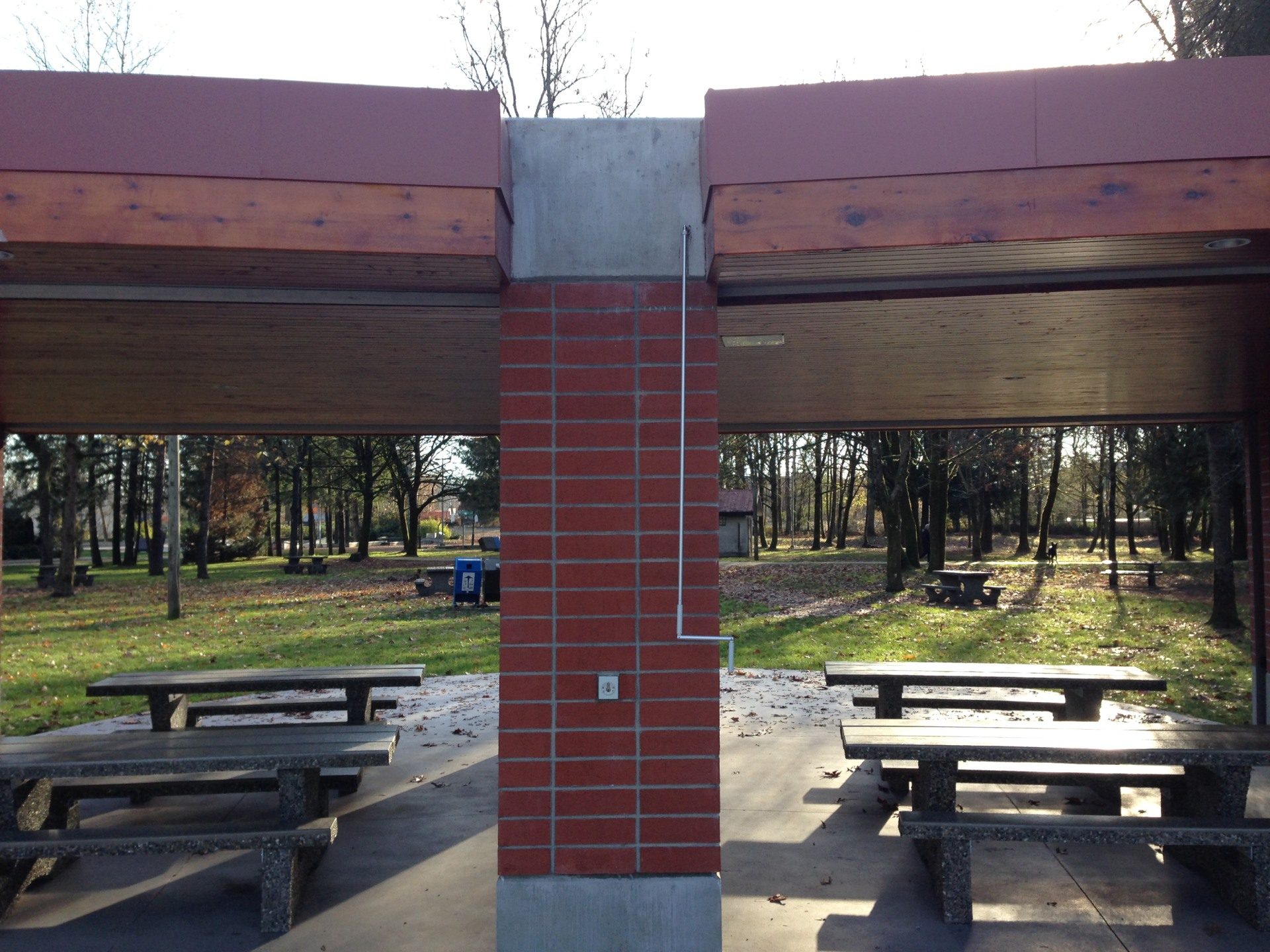 Park picnic pavilion with roll shutters retracted into the roof beams above open bays