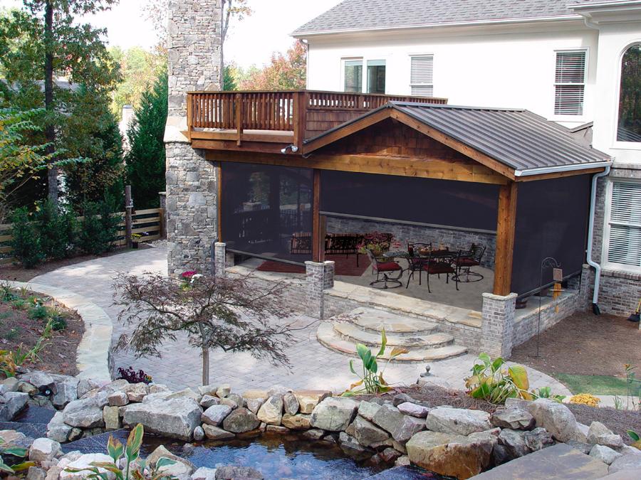 Covered backyard patio enclosed with roll-up screens