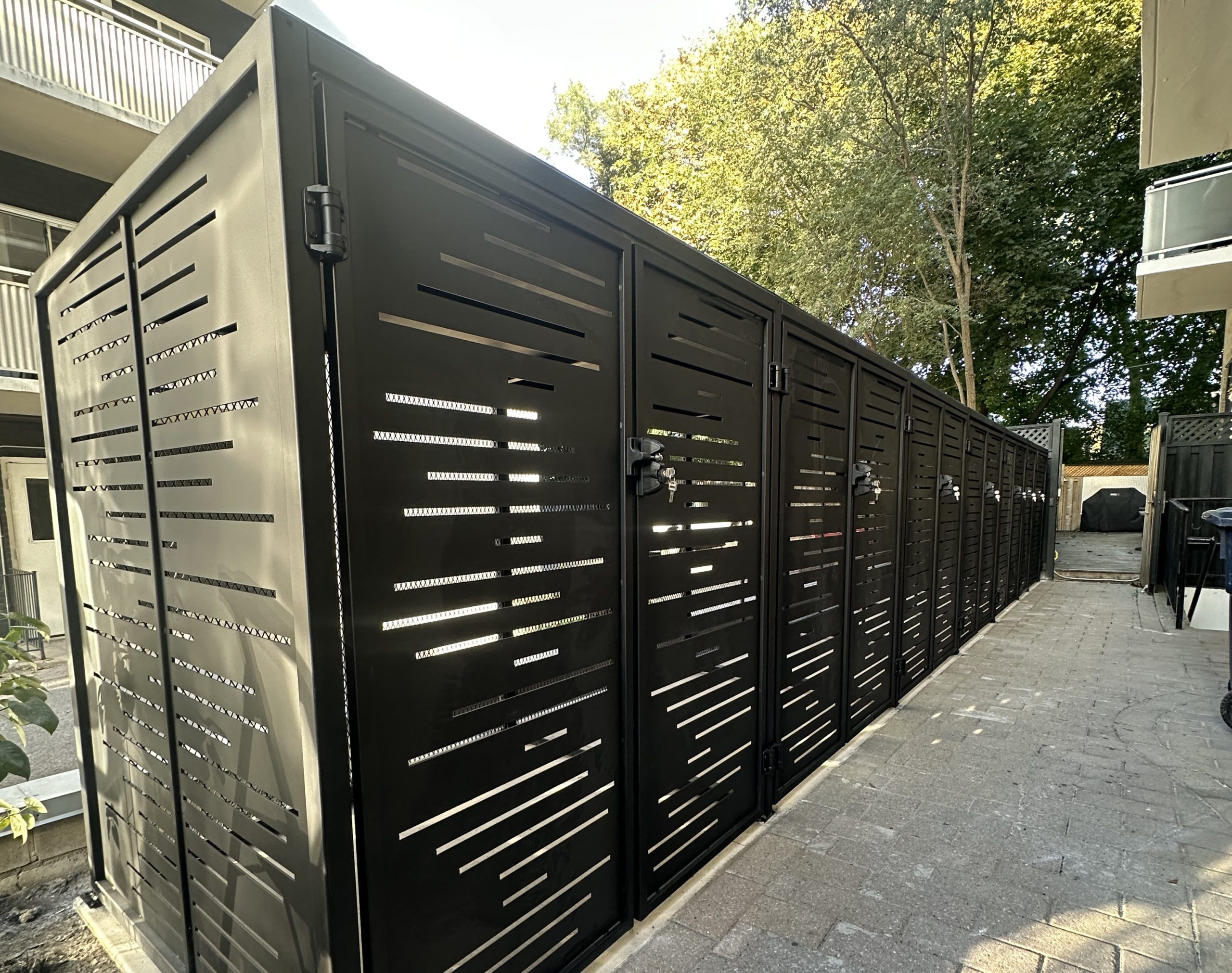 Lockable black metal equipment enclosure with screened panels