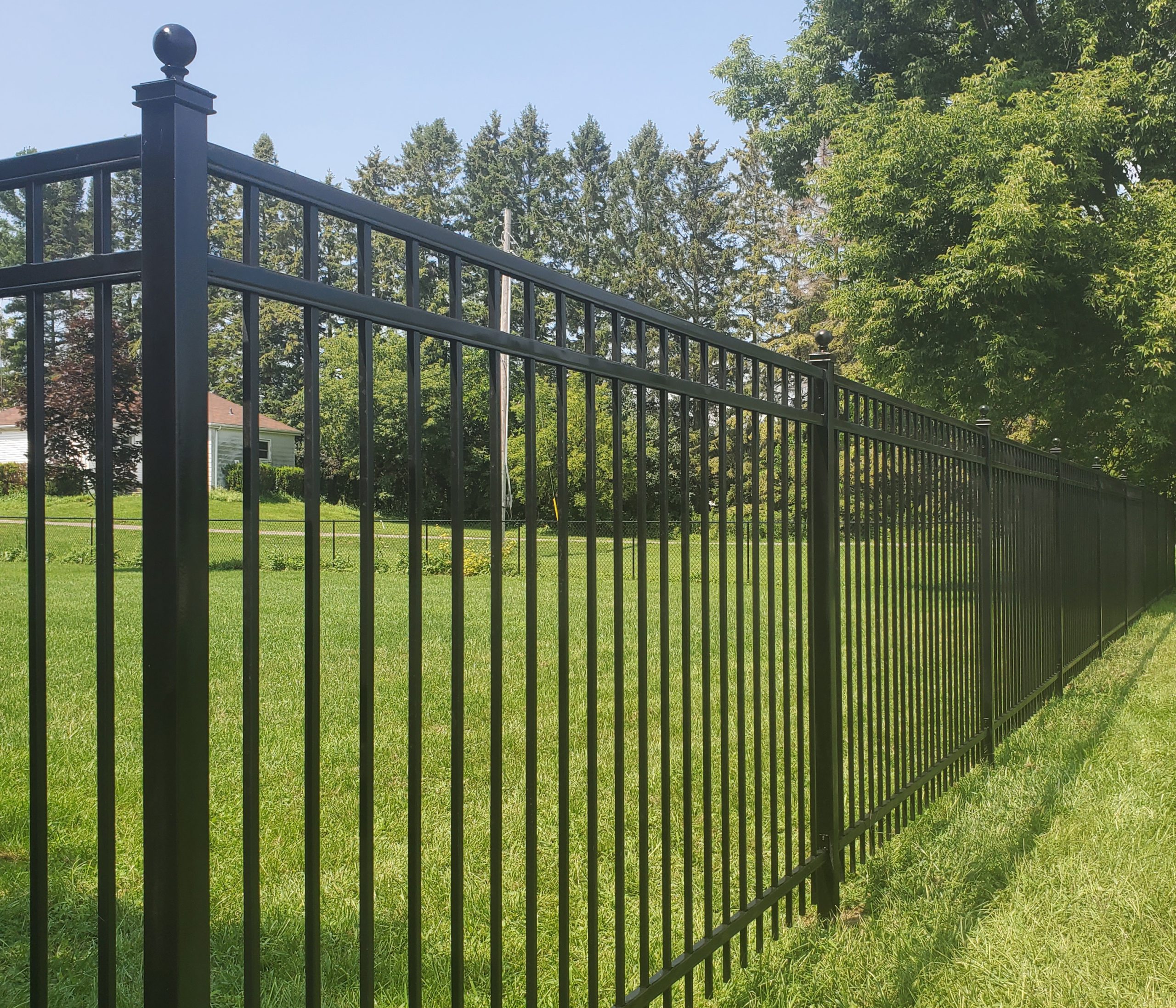 Decorative black metal fence panel used as a residential security boundary