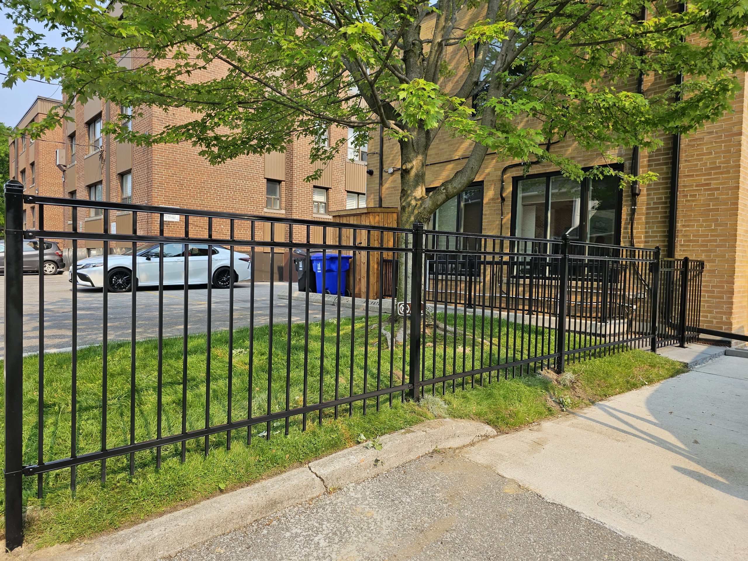 Long run of black metal security fencing around a residential building edge